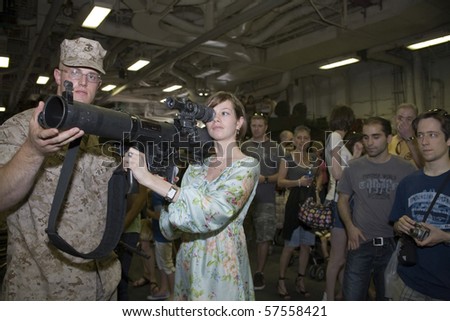 NEW YORK, NY - MAY 23: United States Marinehelps civilian with an M224 weapon.  Photographed during Fleet Week aboard the USS Iwo Jima May 23, 2009 in NYC.
