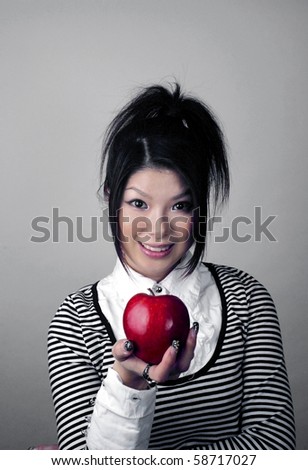 Asian woman holding apple.  She is Japanese and was 23 years old at the time of shoot.
