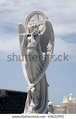 statue of angel in praise of God at cemetery.