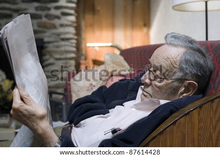 A senior man rests and reads his paper.