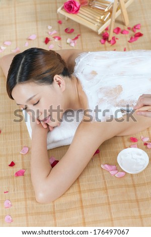 A young lady enjoy body mask in spa salon