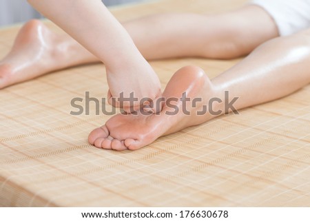 Foot massage for young lady in spa salon