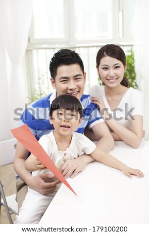 Family of three playing paper airplane