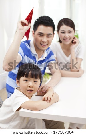 Family of three playing paper airplane