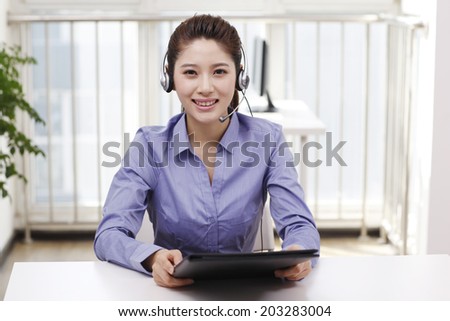 Businesswoman with headset reading portfolio
