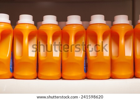 Row of orange bottles of laundry detergent