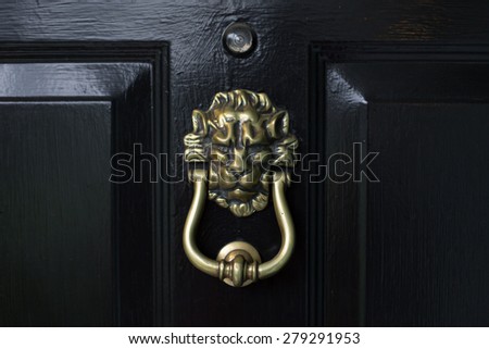 Lion head door knocker on a black door