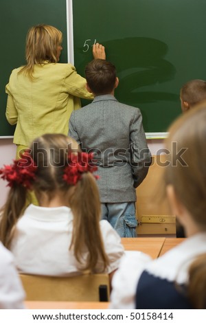 Children together with the teacher in a classroom at a mathematics