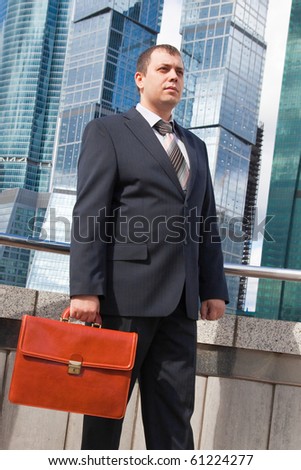 Young businessman with a briefcase on the background of skyscrapers