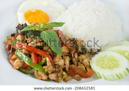 Spicy ground meat over rice with sauteed chopped, fresh chili and garlic, bell pepper, basil leaf, fried egg and cucumber