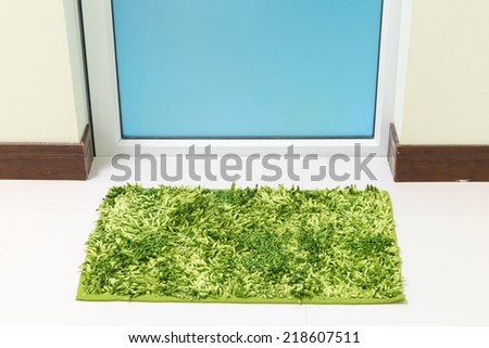 Green cleaning feet doormat or carpet in front of toilet door look dirty