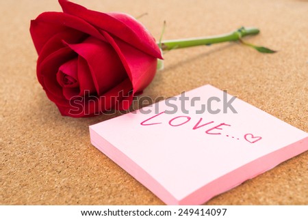 Single red rose with post it with word \