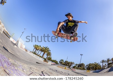 ARRECIFE, LANZAROTE - MARCH 31: boy jumps with his skate board over a ramp at the skate park on March 31, 2013 in Arrecife, Lanzarote. The skate park was inaugurated in 2005 and is free of charge.