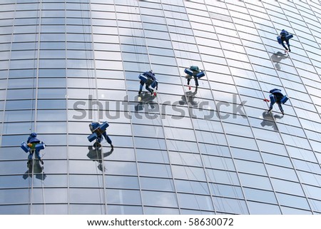Six washers wash the windows of modern building