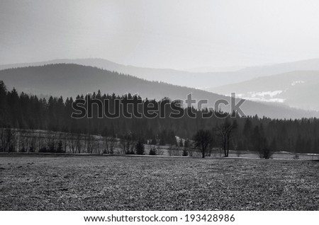 Black and white landscape of hills, mountains and valley in the fog