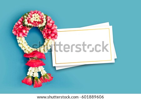 Thai traditional jasmine garland and blank white greeting card (Use for respect to parent and the old man in Songkran festival or Mother\'s day in Thailand) isolated on blue background