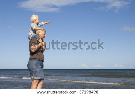 Young blonde girl sitting on her mothers shoulder