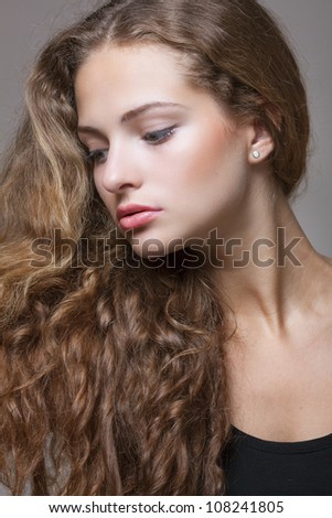 Closeup portrait of a beautiful young brunette woman with natural makeup, perfect skin and gorgeous curly hair