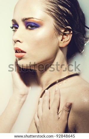 Close-up fine art portrait of a beautiful sexy young woman with creative eye makeup in water