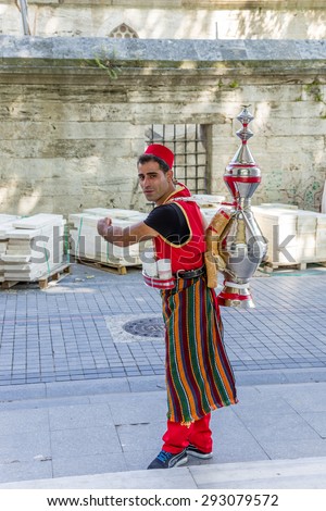 ISTANBUL, TURKEY - JUN 22, 2014: Peddler drinks in national dress