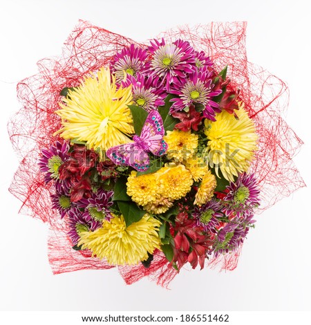 bouquet of yellow chrysanthemums and pink with a toy butterfly with crystals on a white background