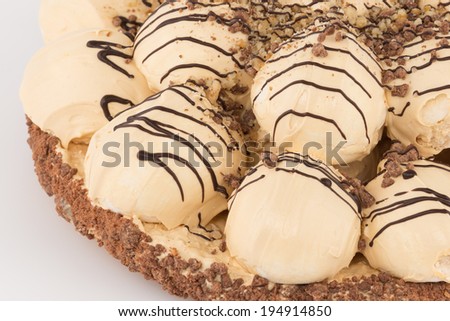 part meringue cake with dark chocolate and ground nuts on a white background