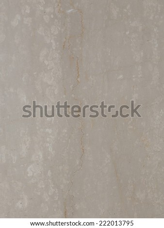 large slab of solid smooth beige marble with brown streaks and light spots
