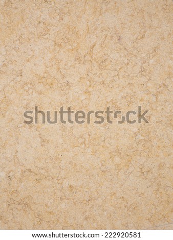 large slab of mottled beige and yellow marble with a smooth polished surface and smooth brown spots