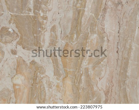 large slab of variegated striped beige and brown marble with a flat smooth polished surface