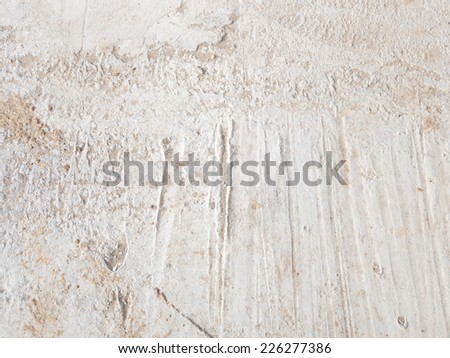 gray concrete floor with small pits and stripes and clogged sand