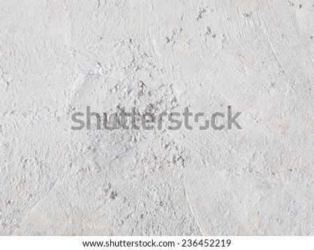light gray floor of the fresh concrete with small dents and pits strips and they huddled orange sand