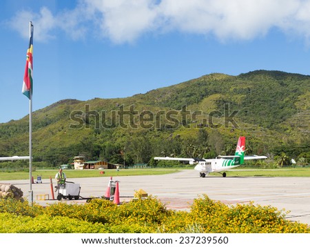 Mahe - October 29, 2014: A small plane was taxiing on the runway and airport workers assemble equipment October 29, 2014, in Mahe, Seychelles