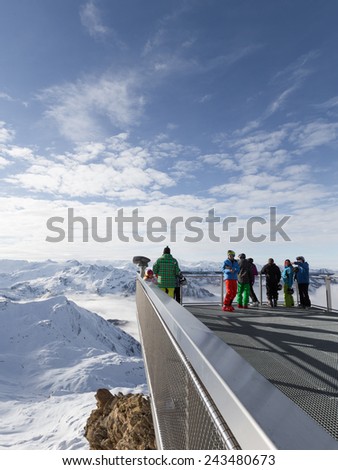 Zell am Cee - December 6, 2014: People in bright jackets on the observation deck admiring the mountain winter landscape in snowy Alps of 6 December 2014, Zell am Cee, Kaprun, Austria