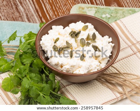 delicious healthy diet cottage cheese with pumpkin seeds and fresh parsley, dill and korianom country style