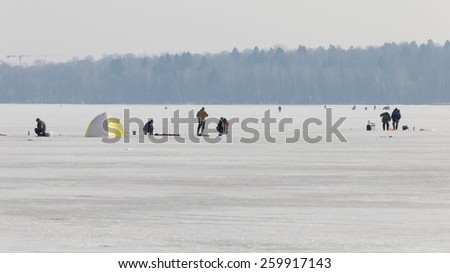 The Moscow region - March 11, 2015: Fishermen catch fish on ice fishing in the hole Pirogov Reservoir and fog away March 11, 2015, Moscow Region, Russia