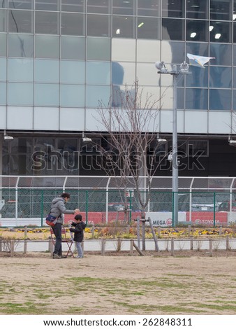 Tokyo - February 7, 2015: Father and young son flying a kite in the pedestrian area of the city in early spring February 7, 2015, Tokyo, Japan