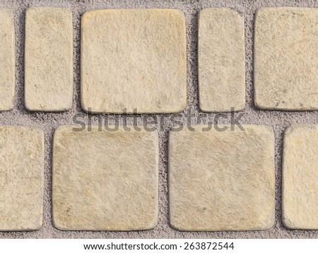 light textured paving tiles imitating stone path with rounded edges and seams are covered with fine marble chips