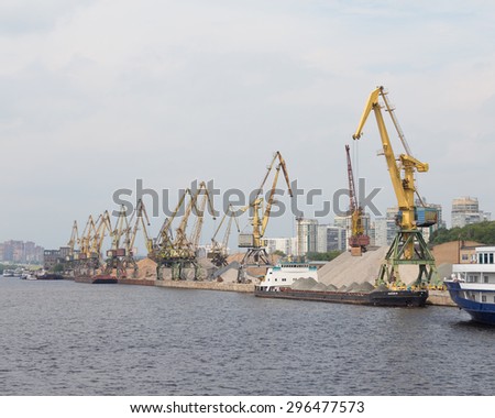 Moscow - July 9, 2015: The large port cranes in the North river port barge loaded with gravel and sand, July 9, 2015, Moscow, Russia