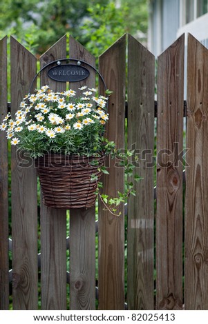Basket with flowers on the fence.
