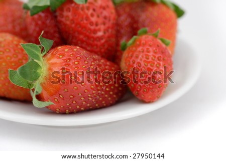 Fresh strawberry on a plate. The close-up fragment. Special focus accent.