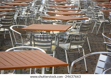 Restaurant tables with brown desktop and metal chairs filling picture space
