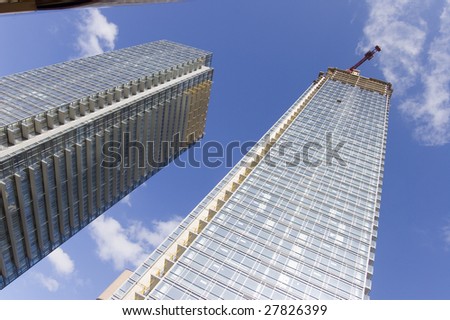 close up of crane on top of high rise building / two skyscrapers