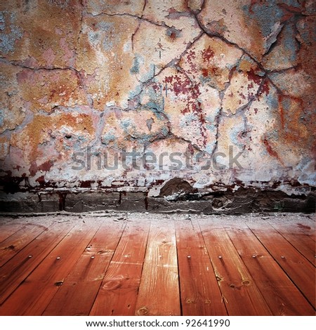 grunge dark brown room with peeled stucco wall, wooden floor
