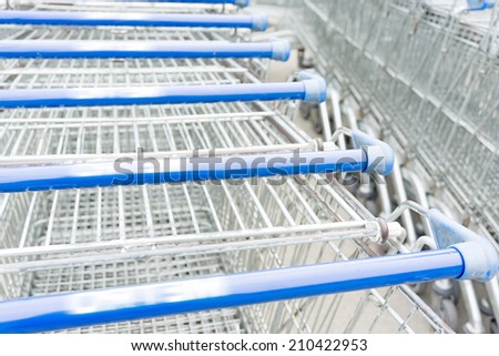 Handlebars of shopping carts in row near supermarket