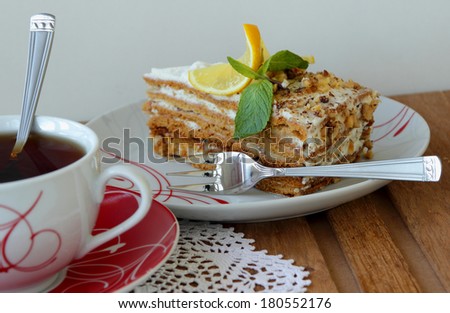 Piece of cake on a plate and cup of tea