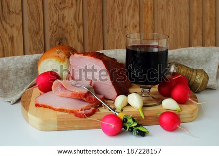 Ham, a glass of red wine, bread and radishes