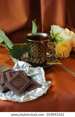 Cup of coffee, roses and chocolate bar