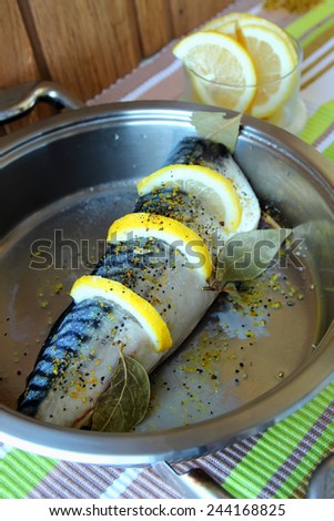 Mackerel, flavored with spices and lemon slices in a pan