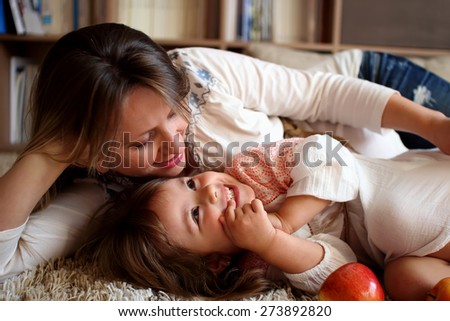 Daughter with her mother laughing and cuddling with happy faces