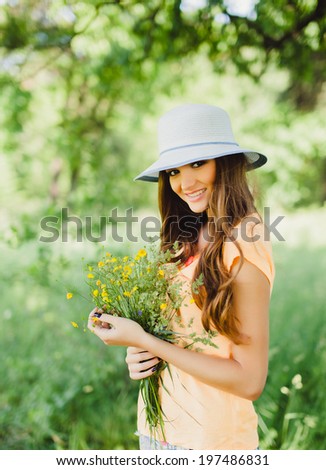young girl posing in the park with flowers